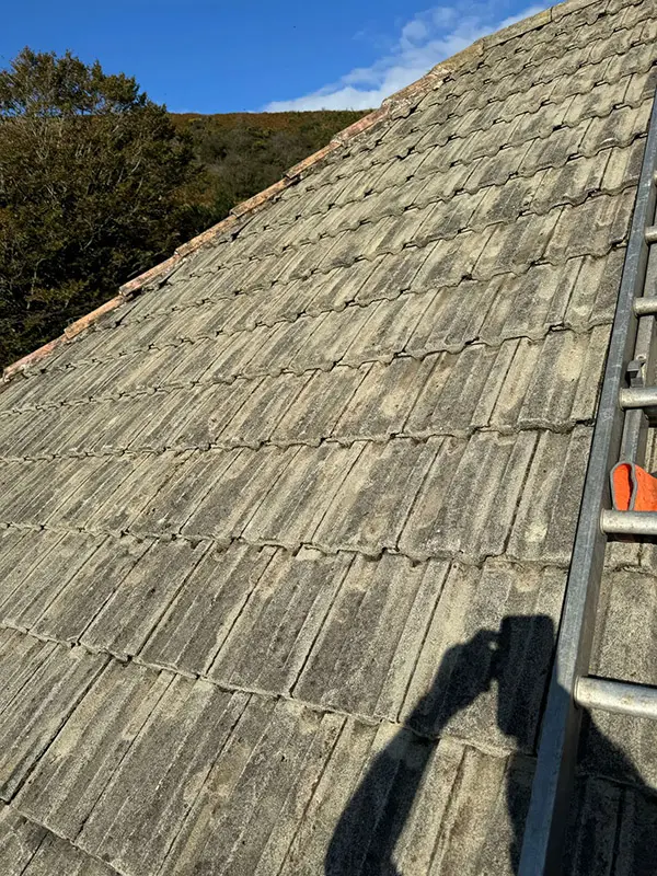 Photograph of a roof being pressure washed clean by Rickard Cleaning Services, Tywyn